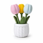 Three crocheted tulip flowers in pink, yellow, and light blue, arranged in a white crocheted pot on a clean white background.