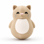 A cute, rounded cat-shaped container or toy in a warm beige/tan color, featuring a white belly panel, black closed eyes, a small pink nose, and white whiskers, set against a clean white background.