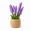 A decorative faux lavender plant with purple flower spikes and green stems, arranged in a round woven beige basket pot on a white background.