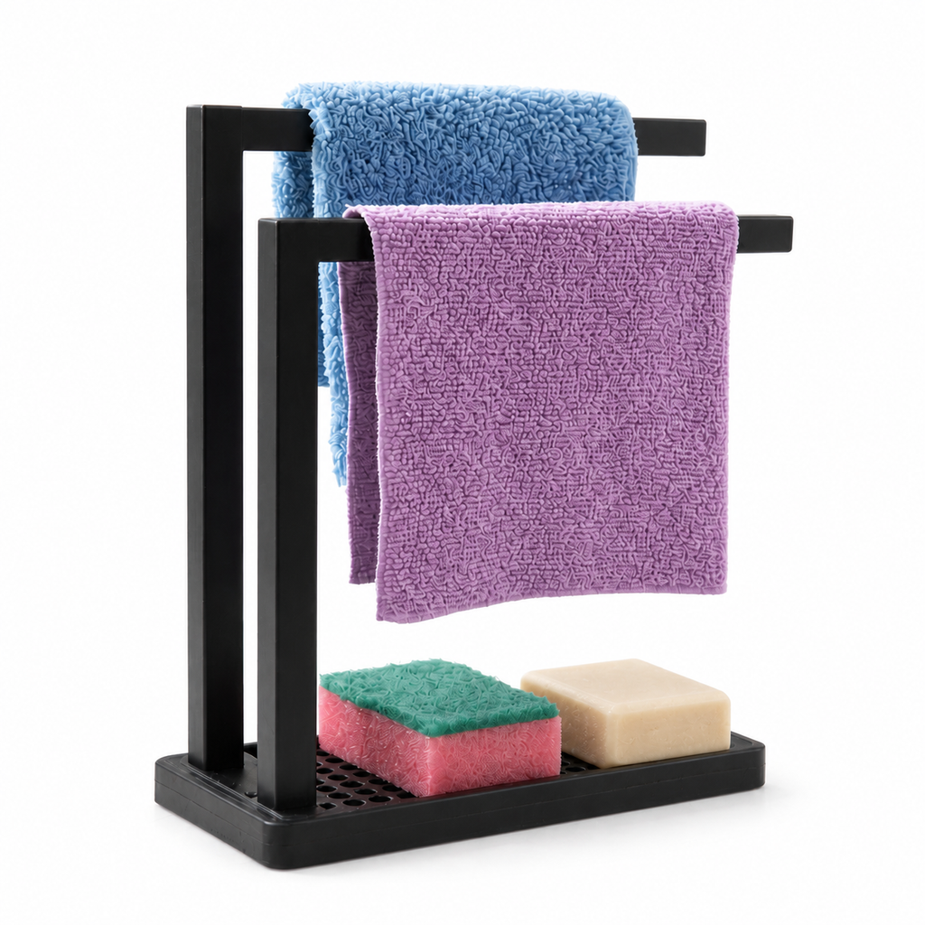 A black metal double towel rack with two towels draped over it and two small cleaning sponges resting on the base, photographed on a clean white background.
