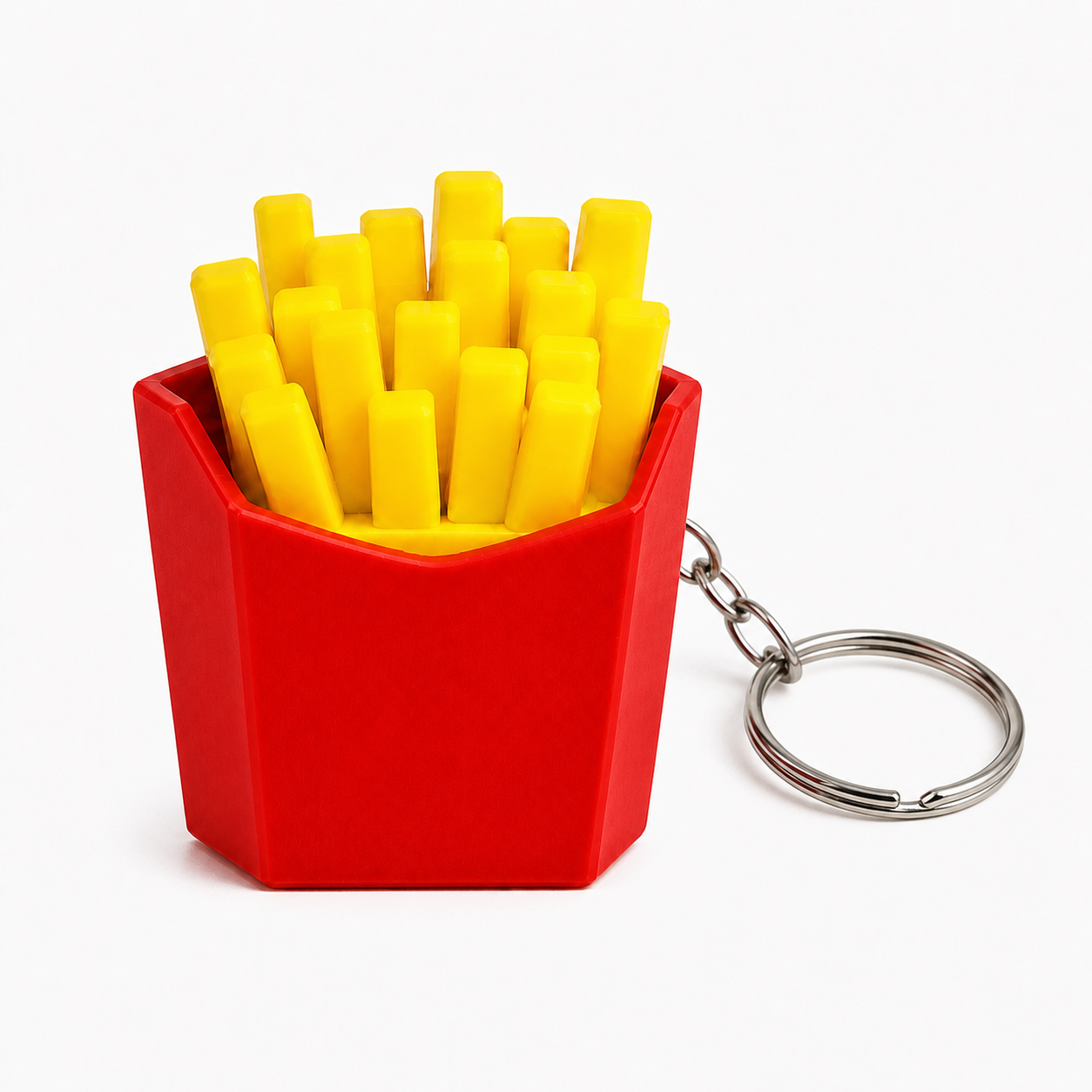 A red french fries keychain container with bright yellow fries and a silver metal keyring, shown on a clean white background.