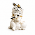A white 3D Printed figurine of lord krishna with black flute, seated next to a small pot, with gold and black decorative accents on the headpiece and jewellery, set against a plain white background.