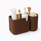 Brown bathroom caddy with toiletries including a tube of cream, bottles, and brushes on a white background