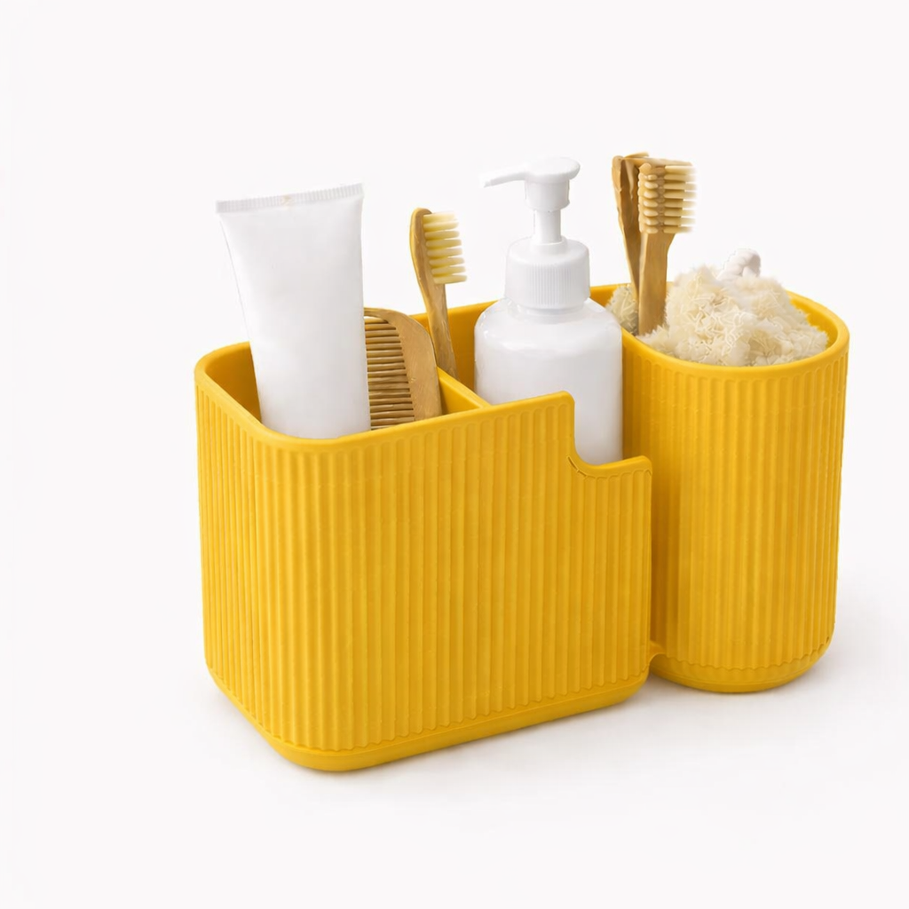 Yellow bathroom caddy with toiletries including a toothbrush, toothpaste, and soap on a white background