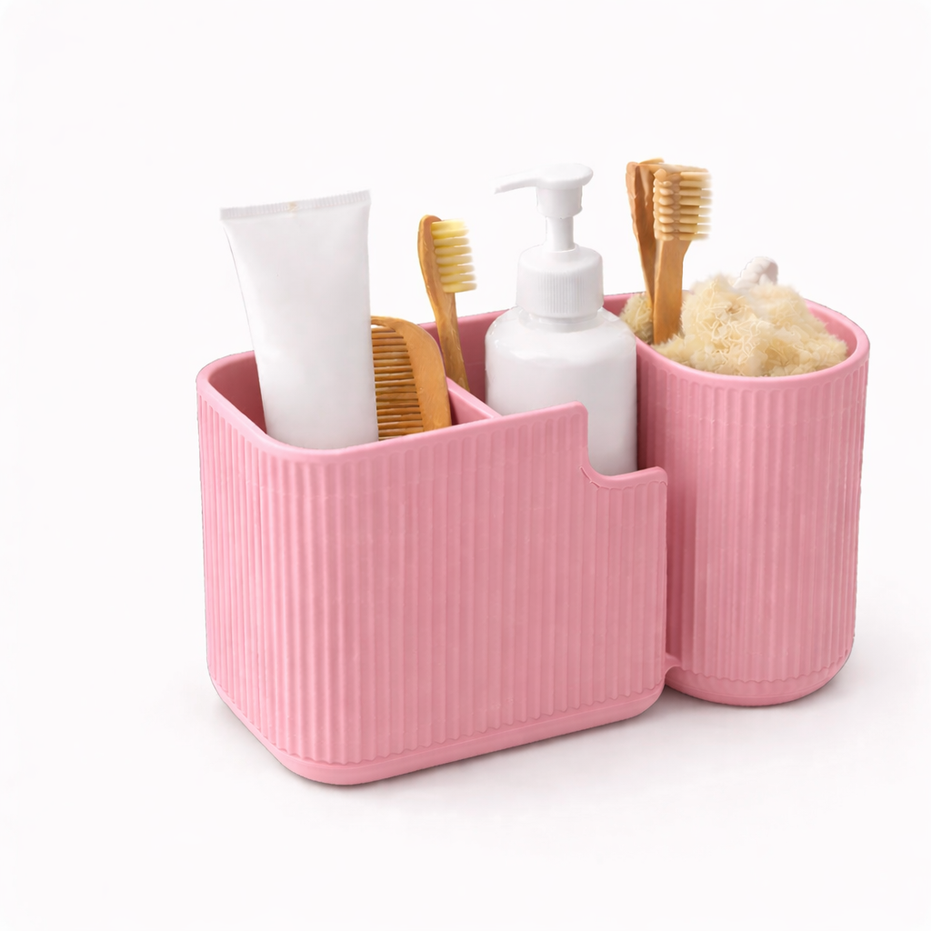 Pink bathroom caddy with toiletries including toothbrushes and bottles on a white background