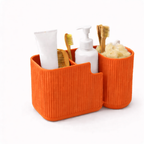 Orange bathroom caddy with toiletries including toothbrushes and bottles on a white background